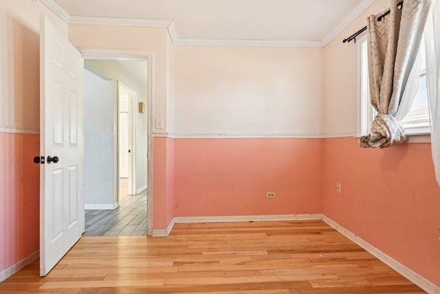 empty room featuring crown molding and light hardwood / wood-style floors