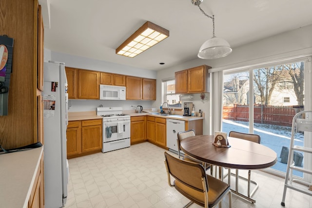 kitchen with sink, hanging light fixtures, and white appliances