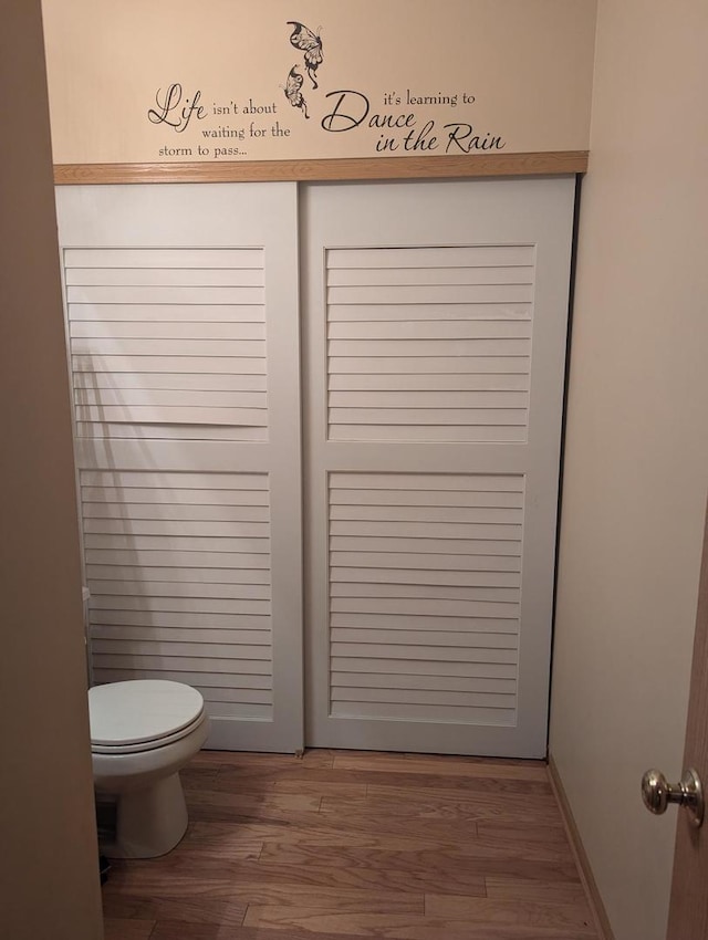 bathroom with toilet and hardwood / wood-style flooring