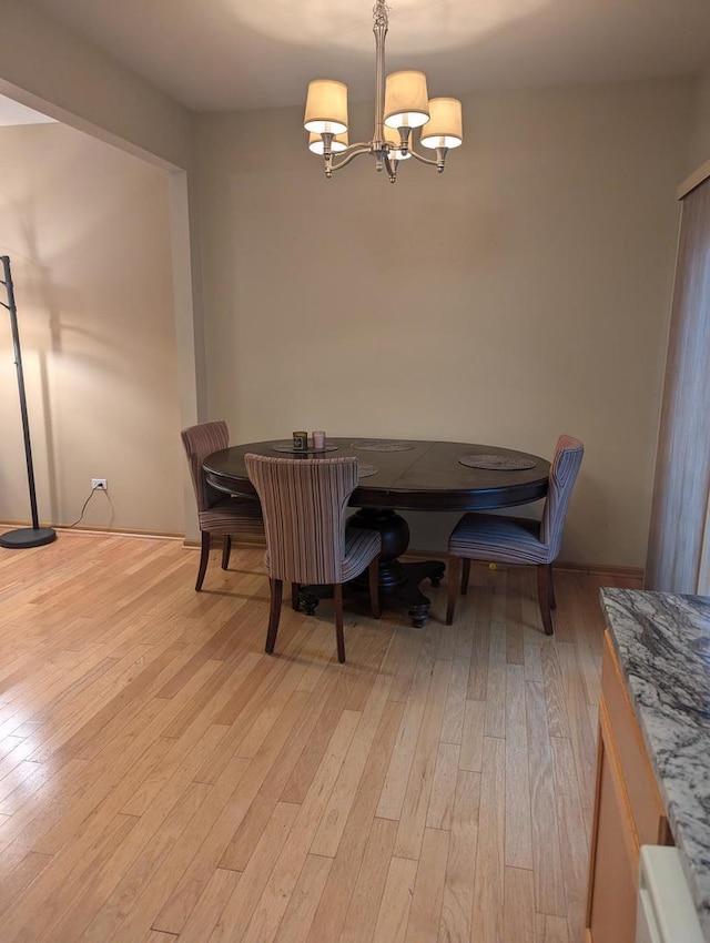 dining room featuring light wood-type flooring and an inviting chandelier