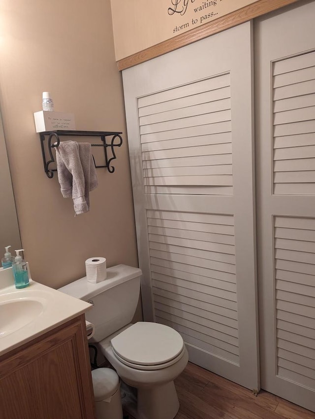 bathroom with toilet, hardwood / wood-style flooring, and vanity