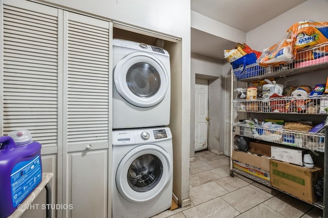 laundry room with light tile patterned floors and stacked washer and dryer