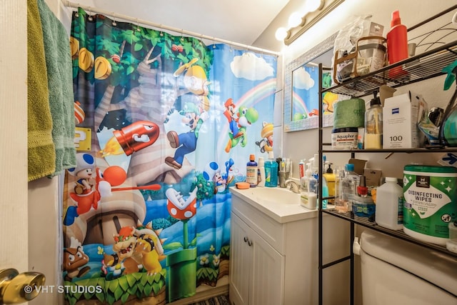 bathroom featuring toilet, vanity, and a shower with shower curtain