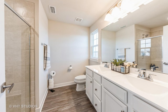 bathroom with vanity, wood-type flooring, a shower with shower door, and toilet