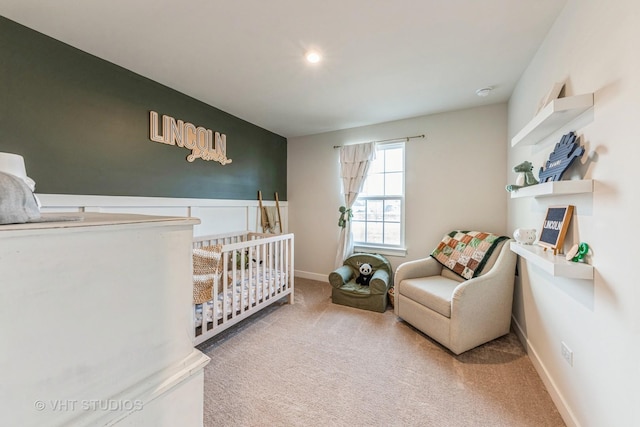 carpeted bedroom featuring a nursery area