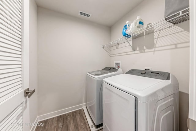 laundry room with dark wood-type flooring and washer and clothes dryer