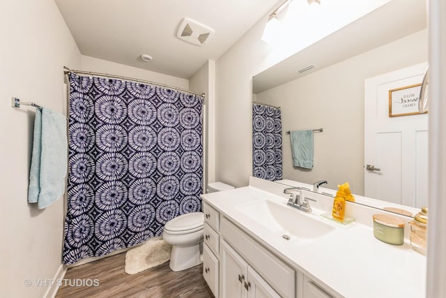 bathroom with hardwood / wood-style flooring, vanity, and toilet