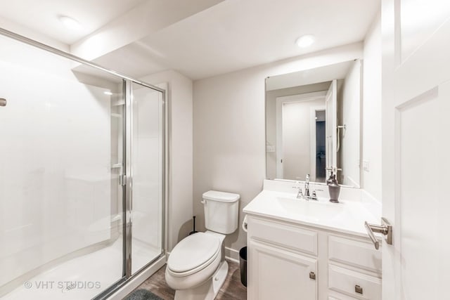 bathroom with vanity, toilet, and a shower with door