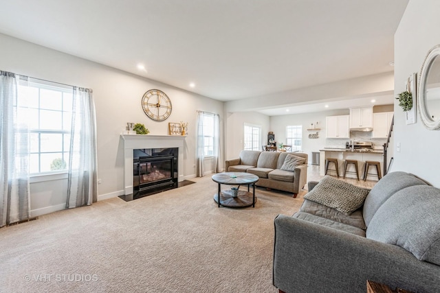 carpeted living room with a fireplace and a wealth of natural light