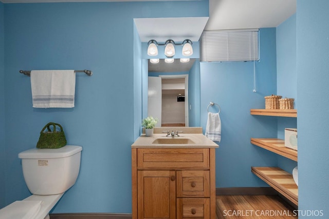 bathroom with hardwood / wood-style flooring, toilet, and vanity