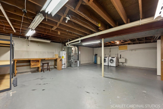 basement with heating unit, water heater, sink, and separate washer and dryer