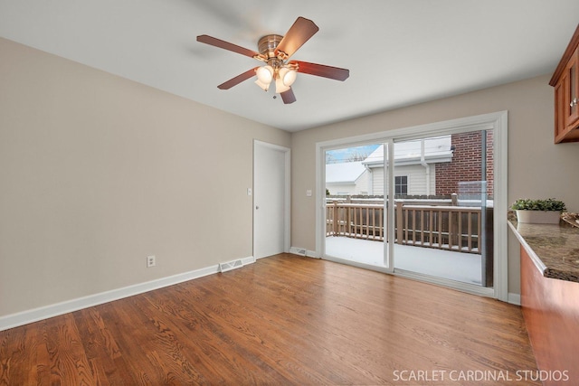 empty room with ceiling fan and wood-type flooring