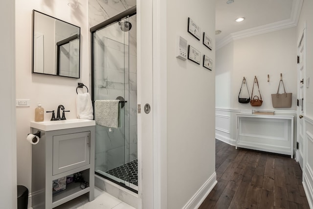 bathroom with crown molding, vanity, an enclosed shower, and hardwood / wood-style floors