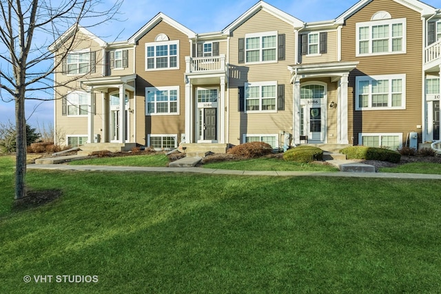 townhome / multi-family property featuring a front lawn