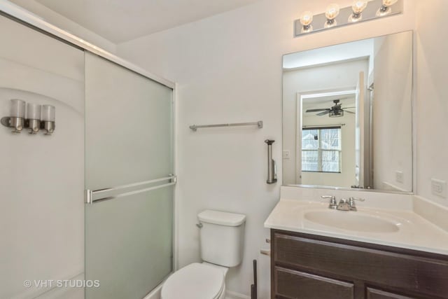 bathroom featuring vanity, walk in shower, ceiling fan, and toilet