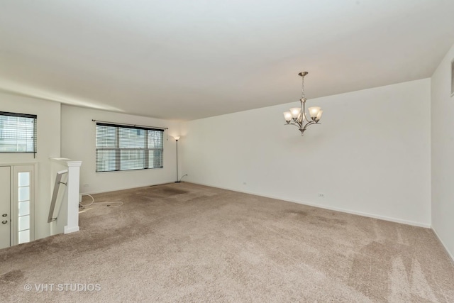 unfurnished living room featuring carpet floors and a chandelier