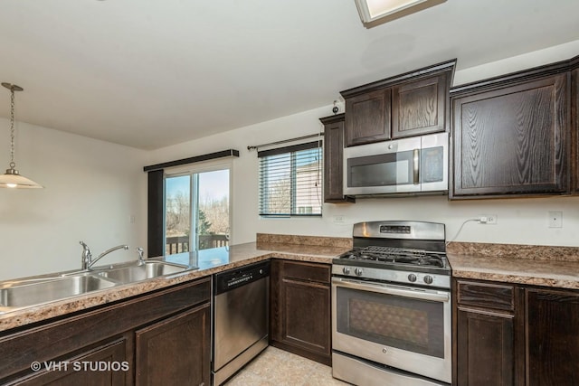 kitchen featuring dark brown cabinetry, sink, decorative light fixtures, appliances with stainless steel finishes, and kitchen peninsula