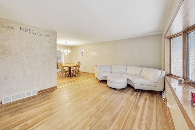 living room featuring light hardwood / wood-style floors and an inviting chandelier