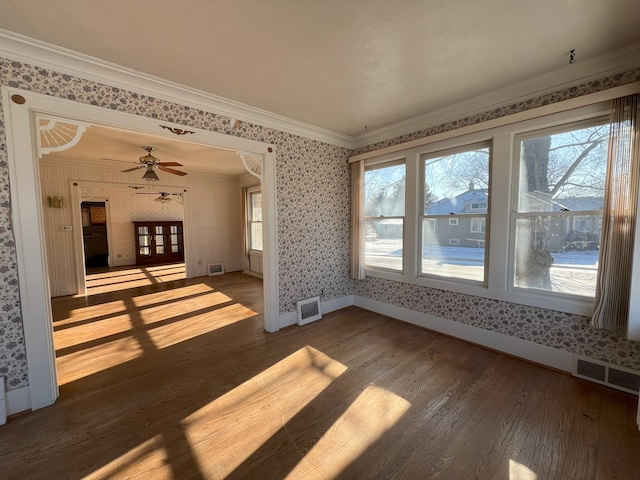 empty room featuring ceiling fan, wood-type flooring, and crown molding