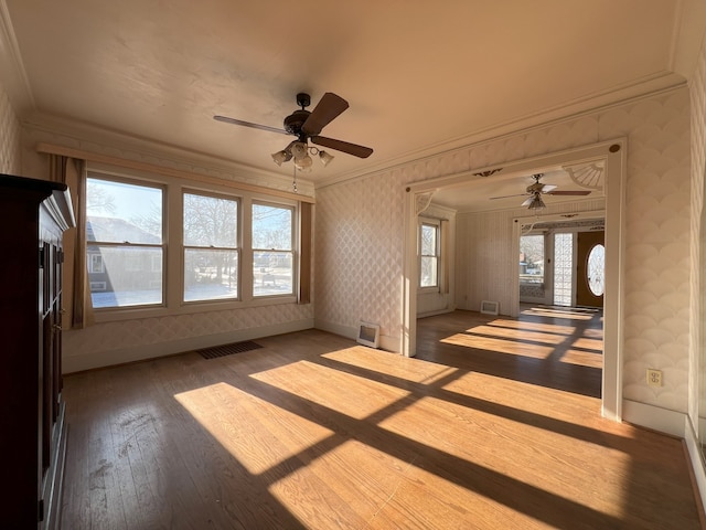 empty room featuring ceiling fan, wood-type flooring, and ornamental molding