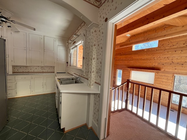 kitchen with ceiling fan, white cabinets, and sink