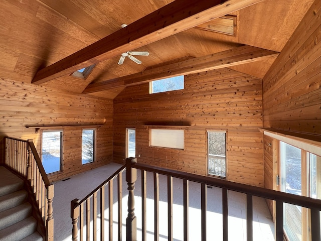 interior space featuring ceiling fan, vaulted ceiling with skylight, and wood ceiling