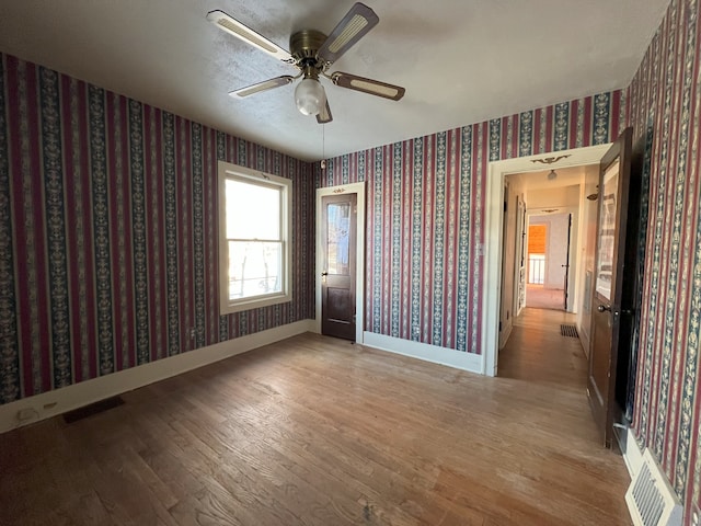 unfurnished room with ceiling fan and wood-type flooring