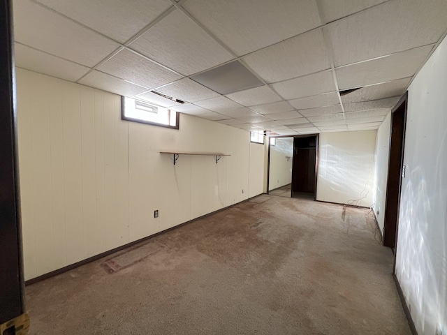 basement with a paneled ceiling and carpet floors