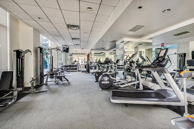 gym with a drop ceiling and carpet