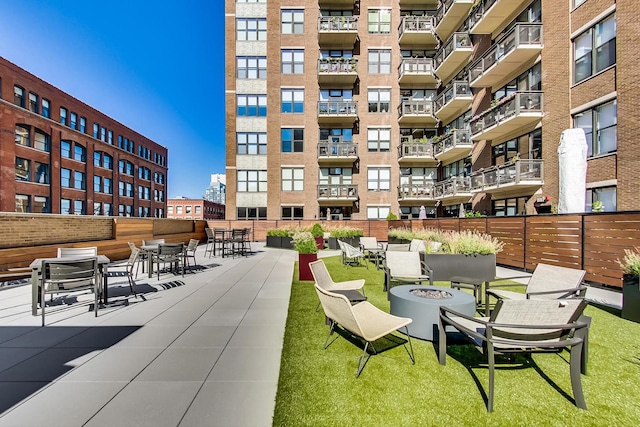 view of community with a patio area, a yard, and a fire pit