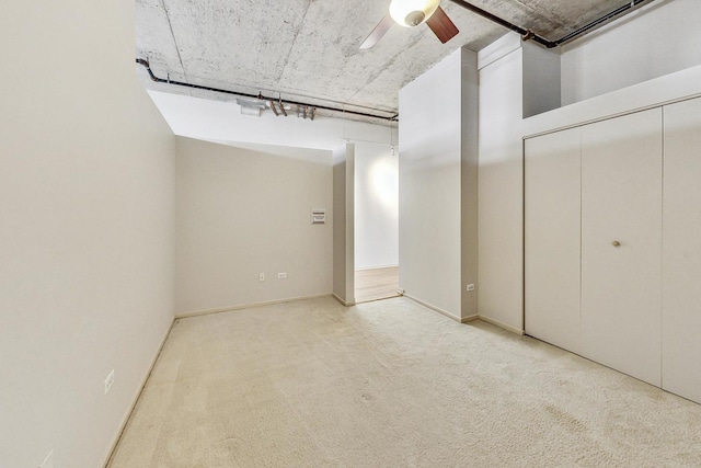 interior space featuring ceiling fan, a closet, and light carpet