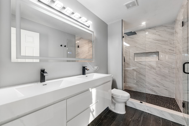 bathroom featuring vanity, toilet, and a shower with door