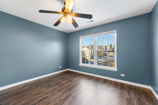 empty room with ceiling fan and dark hardwood / wood-style flooring