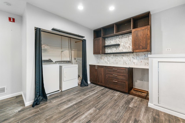 kitchen with dark brown cabinetry, built in desk, and washing machine and clothes dryer