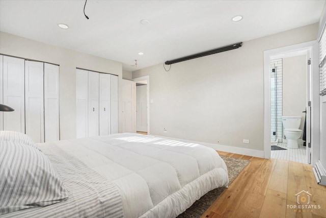 bedroom with connected bathroom, two closets, and light wood-type flooring