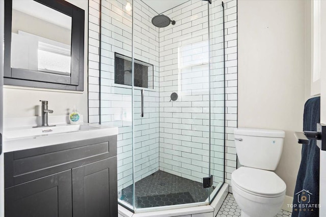 bathroom featuring vanity, toilet, and a shower with door