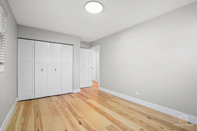 unfurnished bedroom with a closet and light wood-type flooring