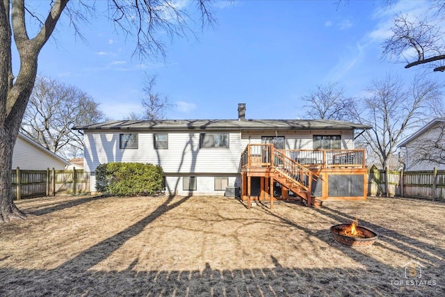 back of property with a deck and a fire pit