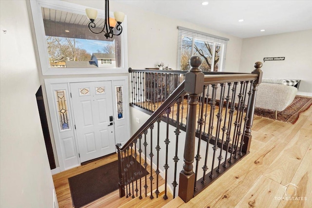 stairs with an inviting chandelier and hardwood / wood-style floors