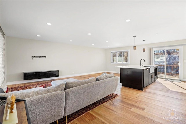 living room featuring sink and light wood-type flooring