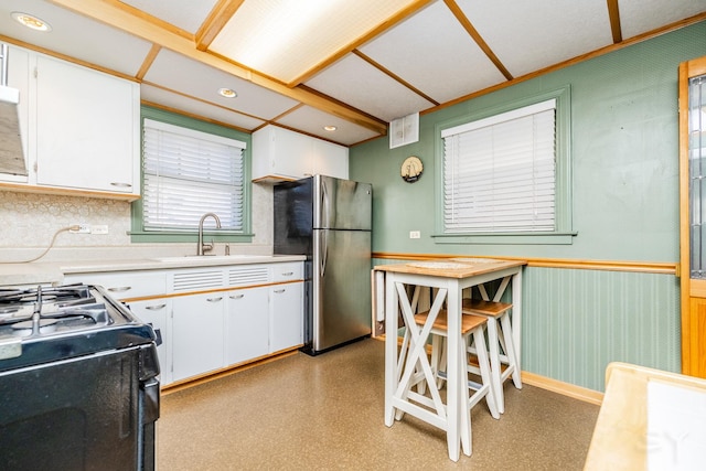 kitchen with sink, white cabinetry, and stainless steel fridge