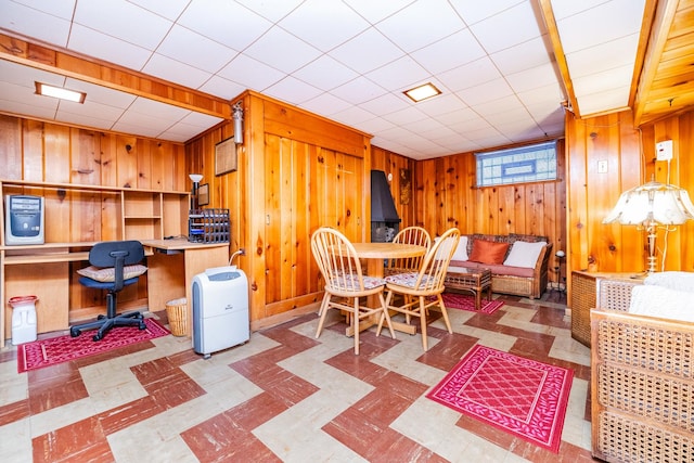 dining space featuring wood walls and built in desk