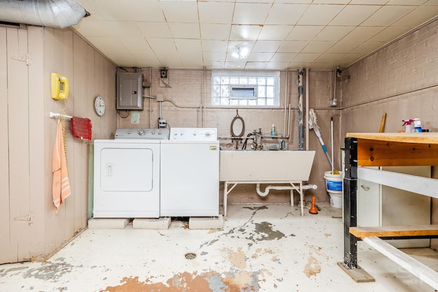 washroom with separate washer and dryer, electric panel, and sink