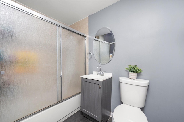 full bathroom featuring toilet, enclosed tub / shower combo, and vanity