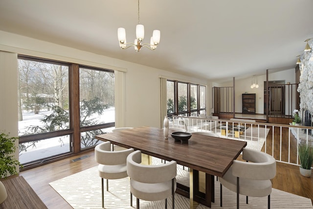 dining space featuring light hardwood / wood-style flooring and a notable chandelier