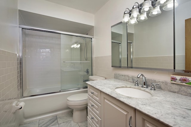 full bathroom featuring combined bath / shower with glass door, vanity, tile walls, and toilet