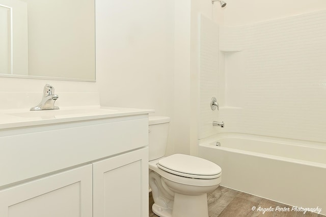 full bathroom featuring vanity, hardwood / wood-style floors, shower / bathtub combination, and toilet