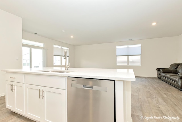 kitchen featuring sink, white cabinets, stainless steel dishwasher, a center island with sink, and light hardwood / wood-style flooring