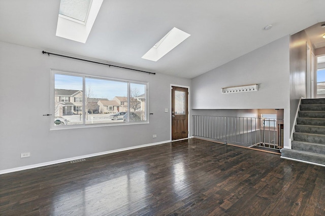 spare room featuring dark hardwood / wood-style floors and vaulted ceiling with skylight