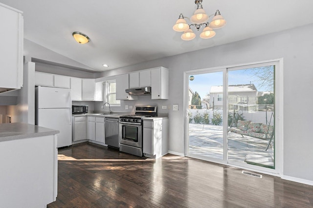 kitchen with lofted ceiling, white cabinetry, stainless steel appliances, dark hardwood / wood-style flooring, and decorative light fixtures